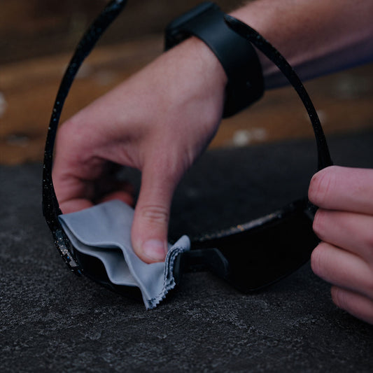 cyclist is using the anti-fog wipe on a pair of glasses
